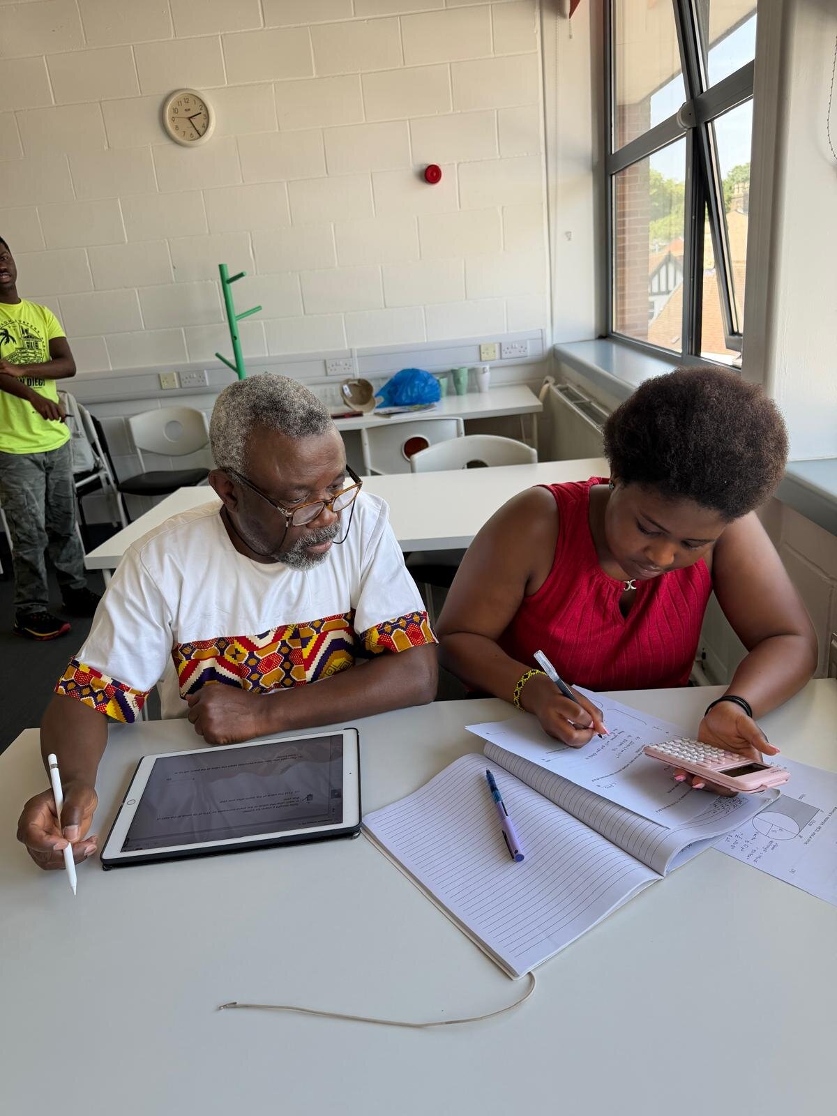 Sylvester Peprah using a tablet to explain a sector area question to a student